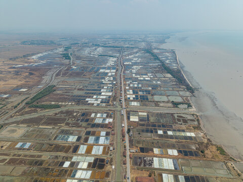 Aerial view of Salt Ponds with rectangular basins and a road running through the landscape in Kedung, Central Java, Indonesia.