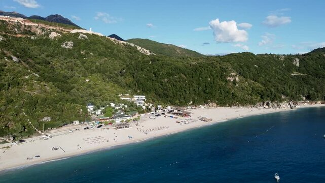 Aerial drone view of a stunning sandy beach along the sea coastline. Blue ocean waves rolling onto a sandy shore. Panoramic coastal landscape.