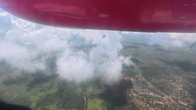 Airplane lowering altitude on approach to land, flying through cloudy sky, air travel arrival