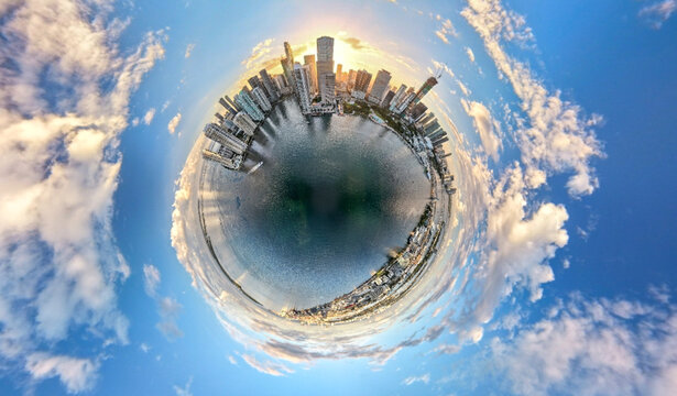 Aerial view of Downtown Miami skyline featuring modern skyscrapers and waterfront views captured in a 360-degree tiny planet perspective under a bright blue sky. Miami, Florida, United States.