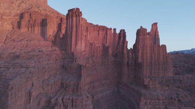 Warm Fisher Towers cliff face rising above a rocky canyon
