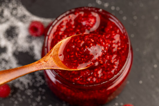 a glass jar filled with grated ripe raspberries, fresh fruit