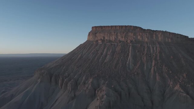 Slow aerial drift beside an isolated desert mesa