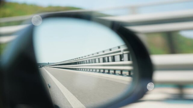 Highway reflected in car side mirror road barrier