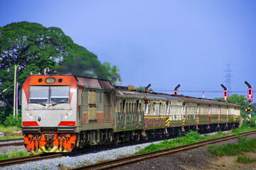 Passenger train by diesel locomotive on the railway in Thailand. © siding_headtrack