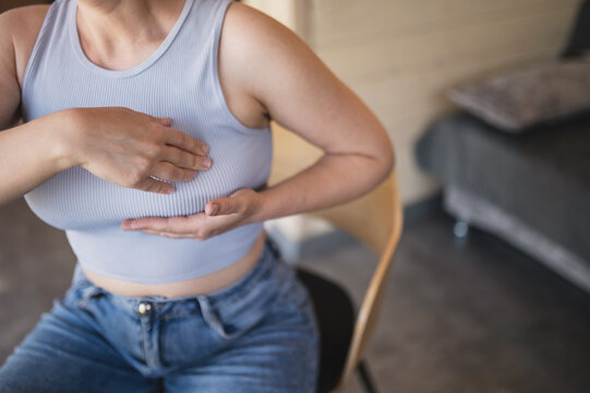 Woman performing breast self-examination at home, representing breast health awareness, breast cancer prevention, early detection, screening, mastopathy, breast pain and women&rsquo;s healthcare