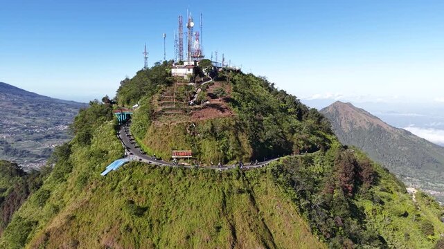 Aerial footage of motorcycle riders touring a scenic mountain route on Mount Telomoyo, Central Java, Indonesia, with panoramic views of surrounding mountains.