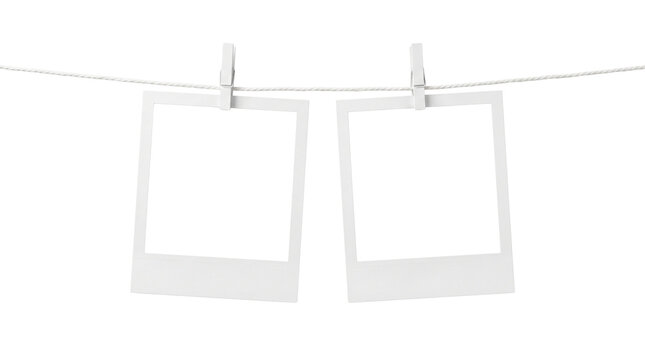 Blank photo frames hanging on a clothesline. Two empty instant picture frames secured with clothespins on white background. Minimalist photography mockup for memories display.