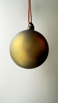 Glass Christmas Bauble Hanging in Soft Light Vertical