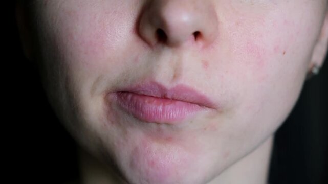 A woman sucking her teeth trying to suck a piece of food out. Something stuck in teeth and she trying to get it out with tongue. Picking at your teeth with your tongue. Facial bad habits. 4K footage.