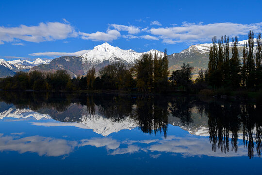 Snow-capped mountain range reflected in a calm mirror lake, Switzerland