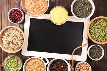 assortment of raw legumes grains seeds and lentils with empty blackboard copy space top view © M.studio