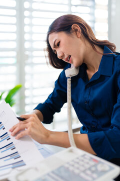 Angry business woman calling on the phone while is watching documents at office. aggressive, furious.