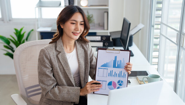 Business woman talking on a video call in office. Business woman having an online meeting with team. Professional business woman doing remote work.