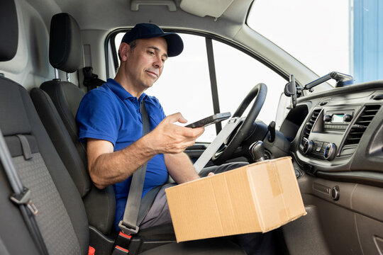Man courier checking recipient information before taking parcel from van