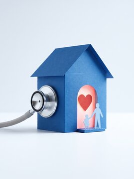 Blue paper house with stethoscope and glowing heart doorway beside paper family