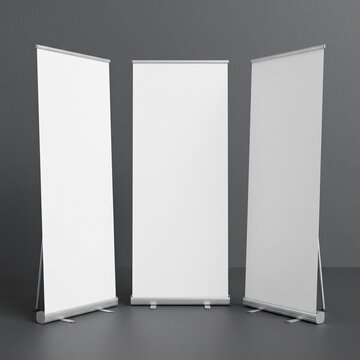 Three blank roll up banner stand mockups on dark background