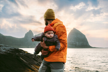 Obraz na płótnie Canvas Father with infant baby enjoying active family holidays outdoors in Norway, happy parenting travel lifestyle parent with kid explore Helgeland islands autumn vacation adventure bonding love childhood