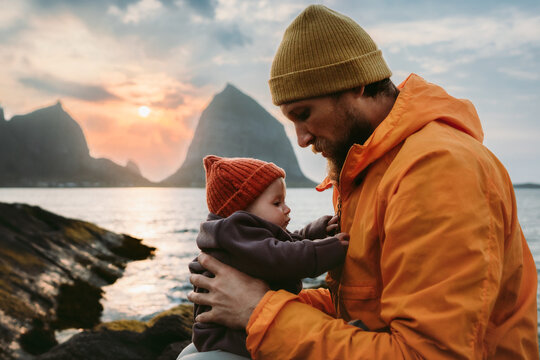 Father and infant baby travel together in Norway family vacation lifestyle, dad walking with child by the sea candid emotions parent with kid explore Helgeland islands outdoor Fathers Day bonding