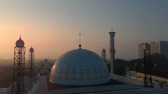 Aerial view of a mosque dome with minarets during golden hour in Malang, East Java, Indonesia.