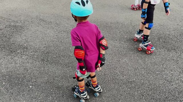 Kid Learning Roller Skating With Helmet Elbow Pads and Knee Protection at day