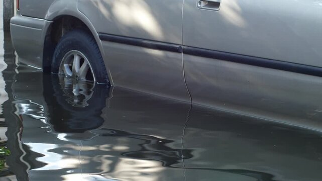 Close-Up of Rusted Vehicle Damaged and Submerged in Floodwater, Total Loss Car Reflecting Nearby Wreckage