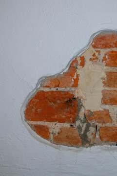 Close-up view of weathered red brick masonry with gray mortar joints showing texture and age. Terracotta brickwork in varied orange and brown tones arranged in horizontal courses with cement pointing.