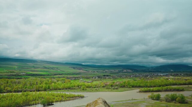 The Mtkvari river valley seen from the rock terraces of the Uplistsikhe cave town under a heavy sky, Georgia.