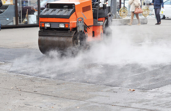 Asphalt pothole patching repair with road roller