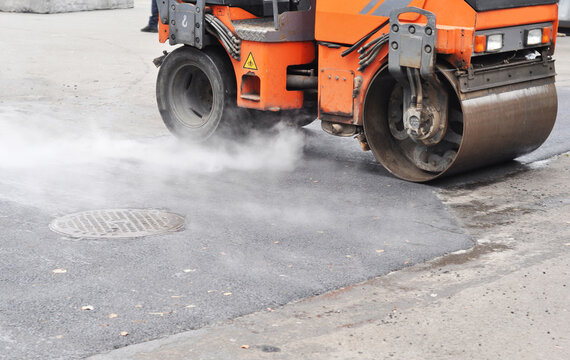 Pothole Patching Repair on Asphalt Road with Road Roller