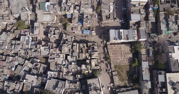 Dense rooftops and narrow streets of a Jaipur neighborhood seen straight down as the camera slowly moves and rotates above them, Aerial View