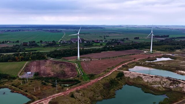 Aerial view of wind turbines in a rural landscape with ponds and fields in Petrasiunai, Siauliu apskritis, Lithuania.
