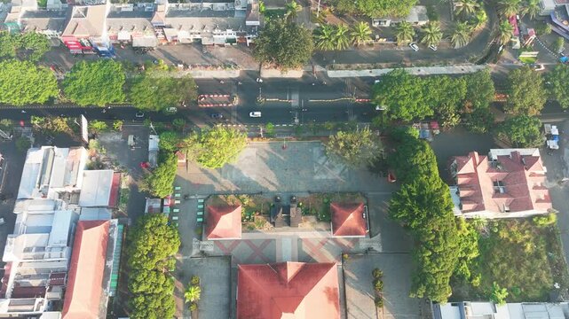 Aerial view of the central square in Malang with surrounding buildings, lush trees, and urban streets in Malang, East Java, Indonesia.