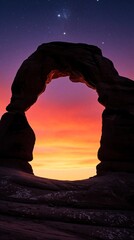 Fototapeta premium Natural sandstone rock arch silhouette against vibrant sunset sky. Colorful orange, purple horizon glows under starry night sky. Beautiful desert landscape with celestial stars, cosmic atmosphere.