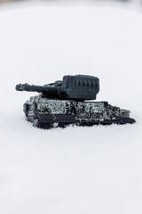 Fototapeta premium Small plastic tank model in winter snow with vertical copy space.