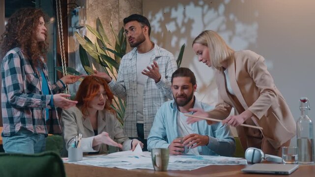 Stressed busy multiracial five coworkers in startup office casual informal business process women men talking discussing papers documents chaos group colleagues coworking working paperwork development