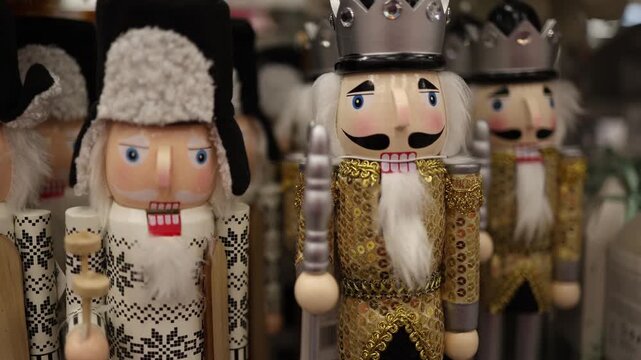 Christmas nutcracker figures in festive costumes stand on a store display with crowns uniforms and traditional wooden designs for seasonal holiday home decoration indoors