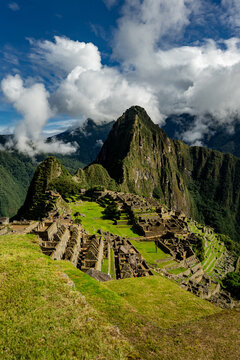 Urubamba Province, Cusco, Peru - 17 March 2025: View of the Historic Sanctuary of Machu Picchu, featuring ancient stone ruins, terraced fields, and Huayna Picchu mountain under a cloudy sky.