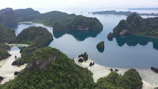 Aerial view of lush green karst islands and turquoise waters at Piaynemo, Raja Ampat, Southwest Papua, Indonesia.