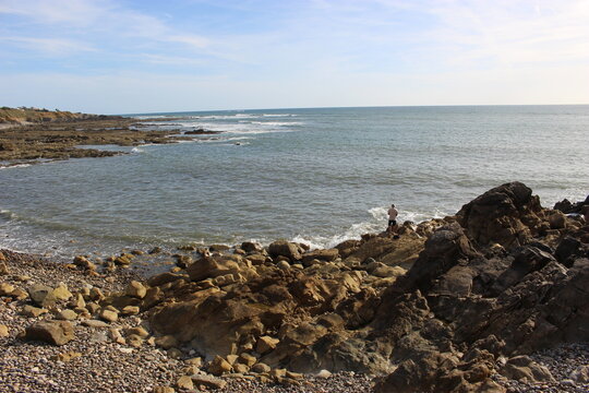 Rochers de la baie de Cayola (commune des Sables-d'Olonne) avec un p&ecirc;cheur &agrave; la ligne