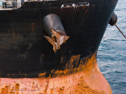 Drone view of heavy anchor on rusty hull of cargo ship in Baltic Sea, Estonia