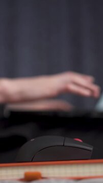 Hand operating mouse with laptop and notepad