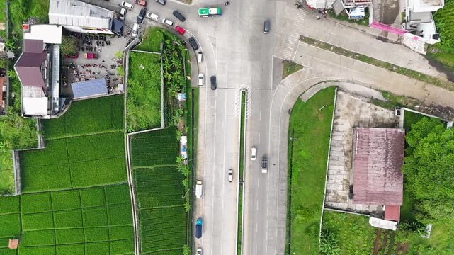 Aerial view of highway passing through lush green rice fields in Soreang, Bandung, West Java, Indonesia.