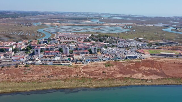 Panoramic aerial perspective showing the town of ayamonte and the vast salt marshes of the guadiana river estuary, highlighting the natural landscape and urban development on a sunny day