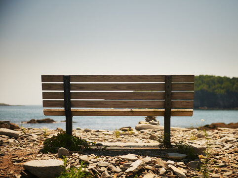 Wooden slatted park bench on the coast of Peaks Island, Maine, New England 