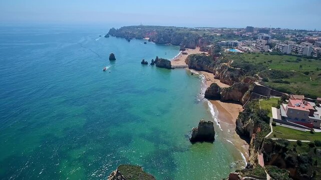 Stunning aerial footage revealing the breathtaking coastline of lagos, portugal, showcasing the famous ponta da piedade cliffs, clear turquoise water, and the sandy shores of camilo beach