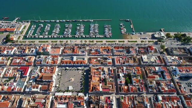 Beautiful aerial descending shot over the historic town of vila real de santo antonio in algarve, portugal, showing the marques de pombal square and the bustling marina on the guadiana river