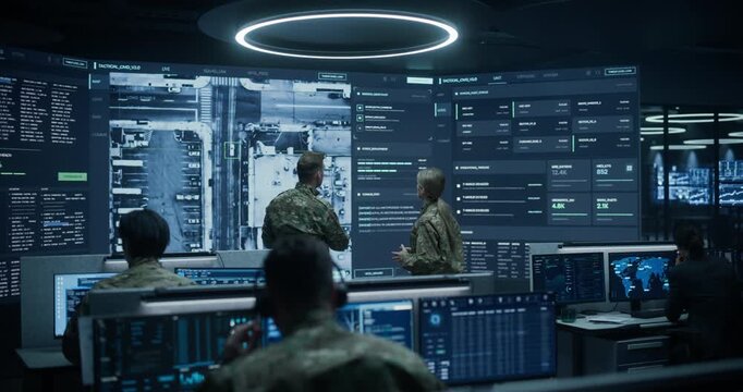 Military Base Monitoring Control Center With Army Surveillance Screens: Officers Brief Soldiers and Intelligence Analysts, Examining Satellite Maps, Tactical Data to Coordinate a Defense Operation.