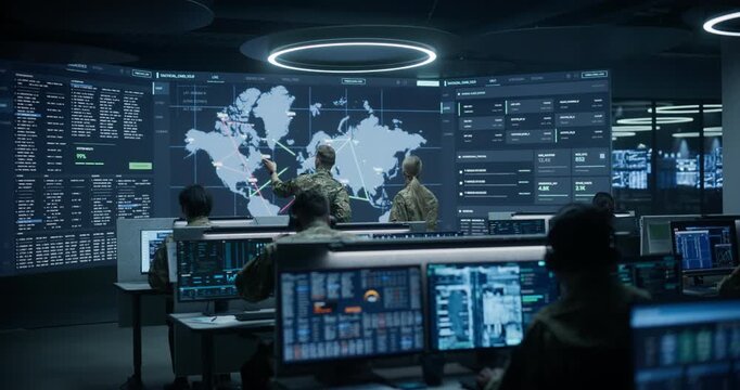 Military Base Surveillance Monitoring Control Room: Two Army Specialists Have a Meeting and Talk in Front of a Global Threat Map, While Intelligence Operators Use Ai Analytics to Track Cyber Attacks.