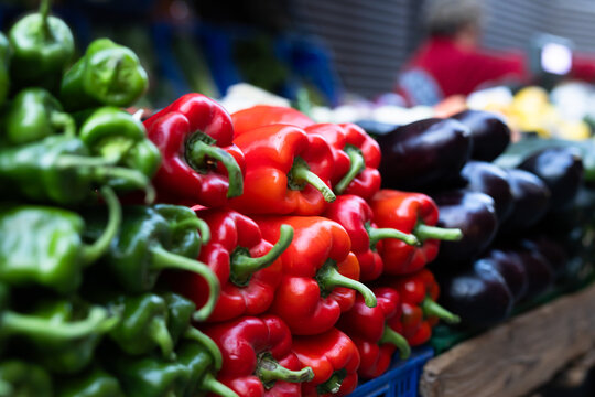 Box is filled with pepper, grocery store display case.